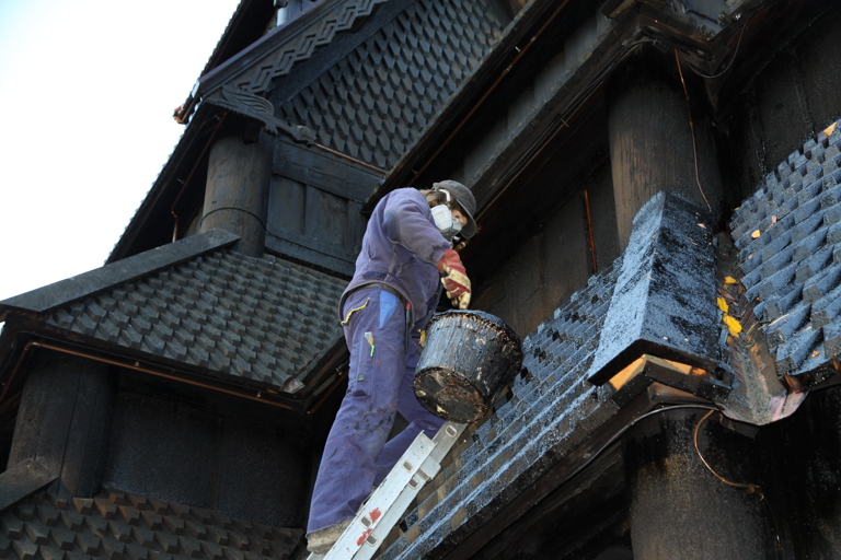 takflater i de pussigste vinkler krever mye tid på stige. Og masken er på! Tjæra utskiller skadelige gasser, spesielt ved oppvarming. Foto: Christel Wigen Grøndahl, Bygg og Bevar