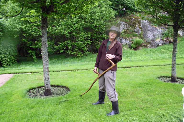 Student Live Røkholt øver på å slå plen med ljå. Gunnebo. Foto: Ingeborg Sørheim