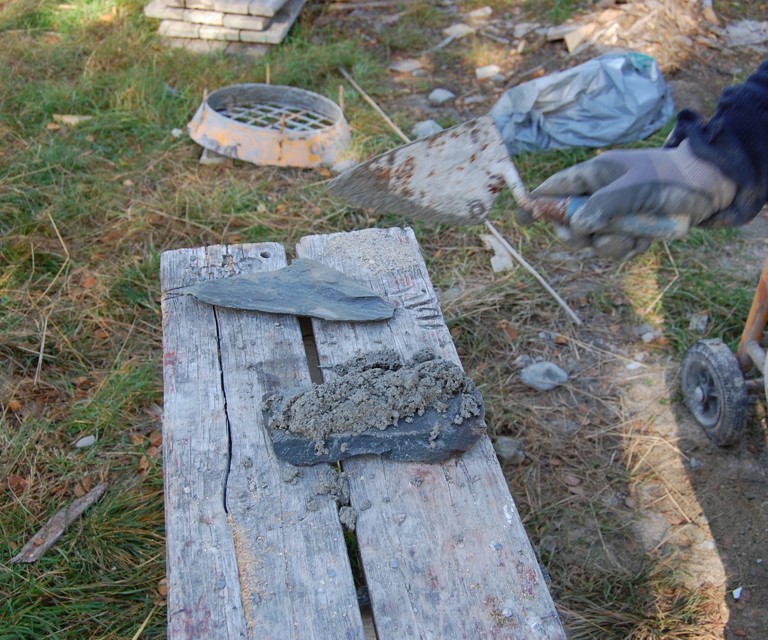Leirmørtel kastes på en stein og en annen stein presses mot mørtelen. Her vises vedheft. Foto: Kulturminnefondet