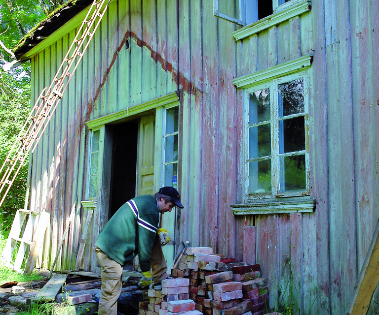 Mursteinen bæres ut og stables opp før den fraktes hjem til gården. Foto: Norske Hjem