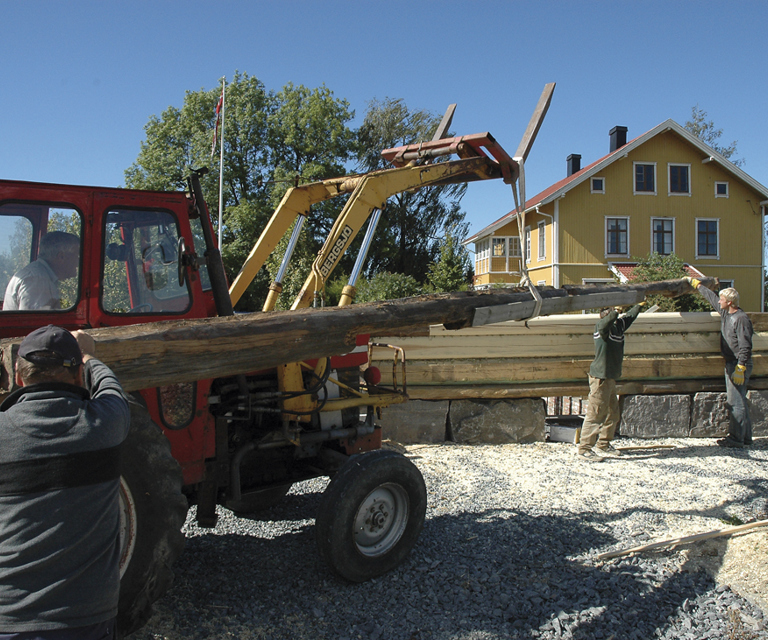 10 meter lang stokk løftes på plass med traktor, så langt det lar seg gjøre. Foto: Norske Hjem