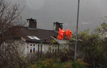 Jobb på taket i kraftig regnvær, Nordnes Bergen. Foto: Christel Wigen Grøndahl, Bygg og Bevar