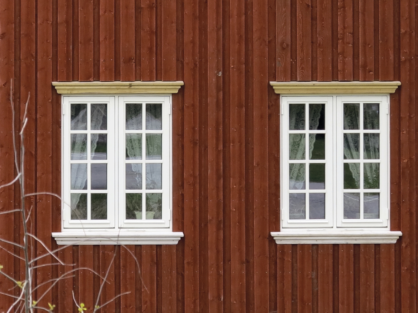 Denne masseproduserte vinduskopien har malte aluminiumsbeslag, enkle kraftige hengsler og falske sprosser. Legg merke til at lysåpningen blir endel mindre enn på originalen til venstre. Livløse glassruter og utenpåliggende kroker. Foto: Norske Hjem